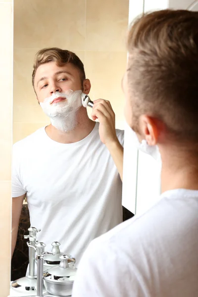 Jovem barbear sua barba no banheiro — Fotografia de Stock