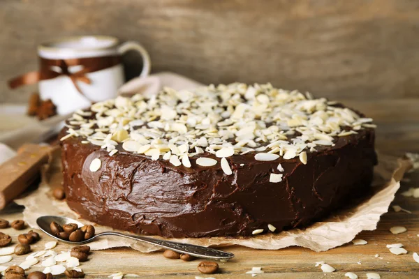 Sabroso pastel de chocolate con almendras, sobre mesa de madera —  Fotos de Stock