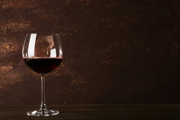 Goblet of red wine on wooden table on wooden wall background — Stock Photo, Image