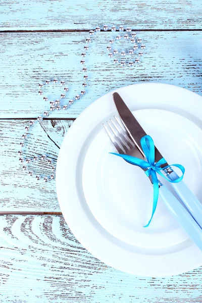 White plates, fork, knife, napkin and Christmas decoration on wooden background — Stock Photo, Image