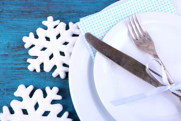 Piatti bianchi, forchetta, coltello e decorazione natalizia su sfondo di legno — Foto Stock