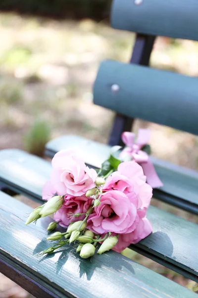 Όμορφης ανθοδέσμης των λουλουδιών eustoma σε ξύλινο παγκάκι στο πάρκο — Φωτογραφία Αρχείου