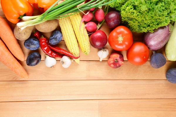 Свіжі органічні фрукти та овочі на дерев'яному фоні — стокове фото