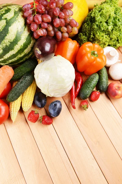 Verse biologische groenten en fruit op houten ondergrond — Stockfoto