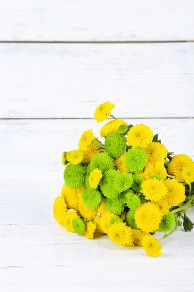 木製の背景に黄色と緑の花 — ストック写真