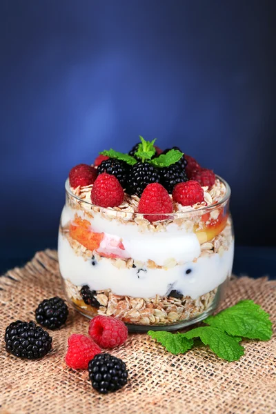 Healthy breakfast - yogurt with  fresh fruit, berries and muesli served in glass jar, on dark color wooden background — Stock Photo, Image