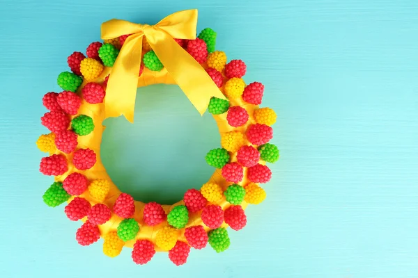 Beautiful wreath of candies on wooden background — Stock Photo, Image