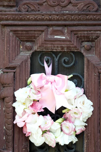 Bela grinalda de flores penduradas na velha porta de madeira — Fotografia de Stock