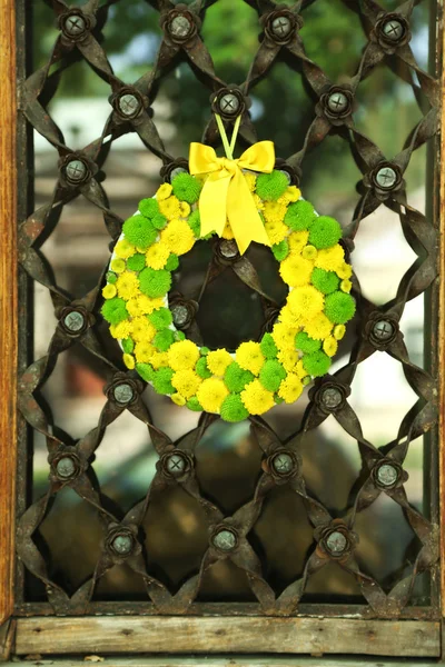 Schöner Blumenkranz hängt an alter Holztür — Stockfoto
