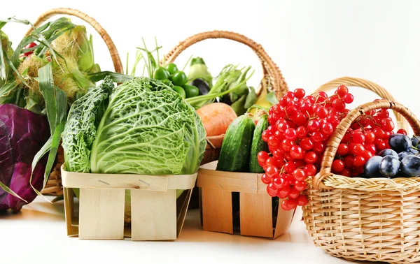 Fresh organic vegetables in wicker baskets, close up — Stock Photo, Image
