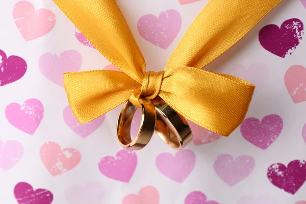 Anéis de casamento amarrado com fita no fundo brilhante — Fotografia de Stock
