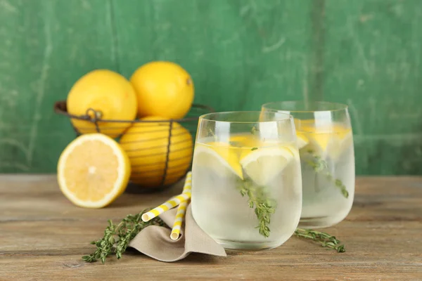 Sabrosa bebida fresca con limón y tomillo, sobre fondo de madera —  Fotos de Stock