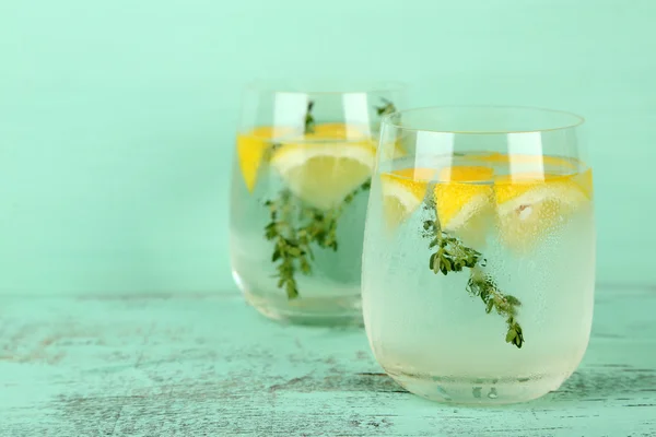 Sabrosa bebida fresca con limón y tomillo, sobre fondo de madera —  Fotos de Stock