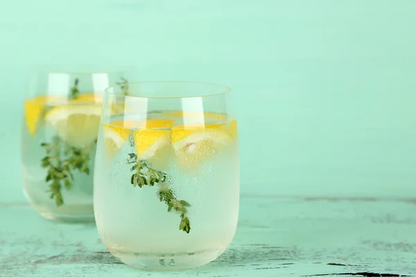 Смачний прохолодний напій з лимоном і чебрецем, на дерев'яному фоні — стокове фото