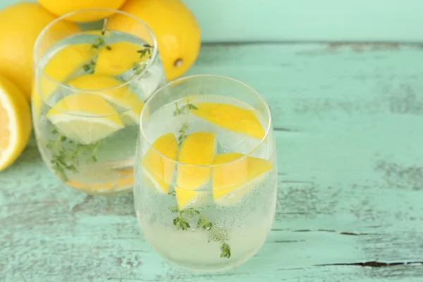 Smakelijke koele drank met citroen en tijm, op houten achtergrond — Stockfoto