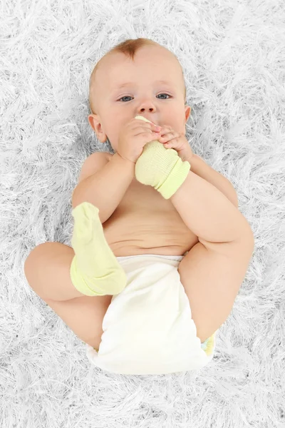 Cute baby boy lying on carpet in room — Stock Photo, Image