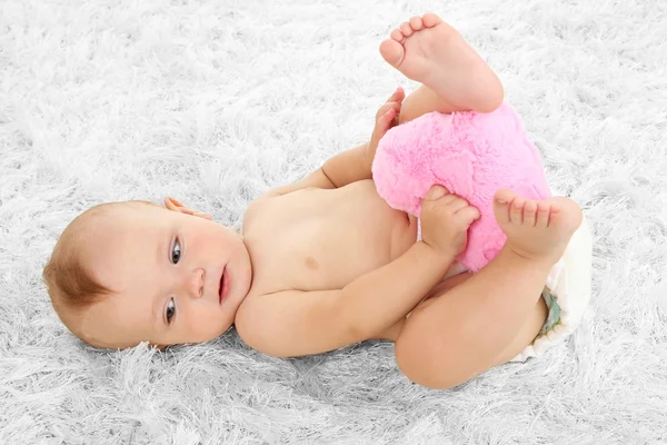 Cute baby boy lying on carpet in room — Stock Photo, Image