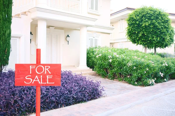 Real estate sign in front of new house for sale — Stock Photo, Image