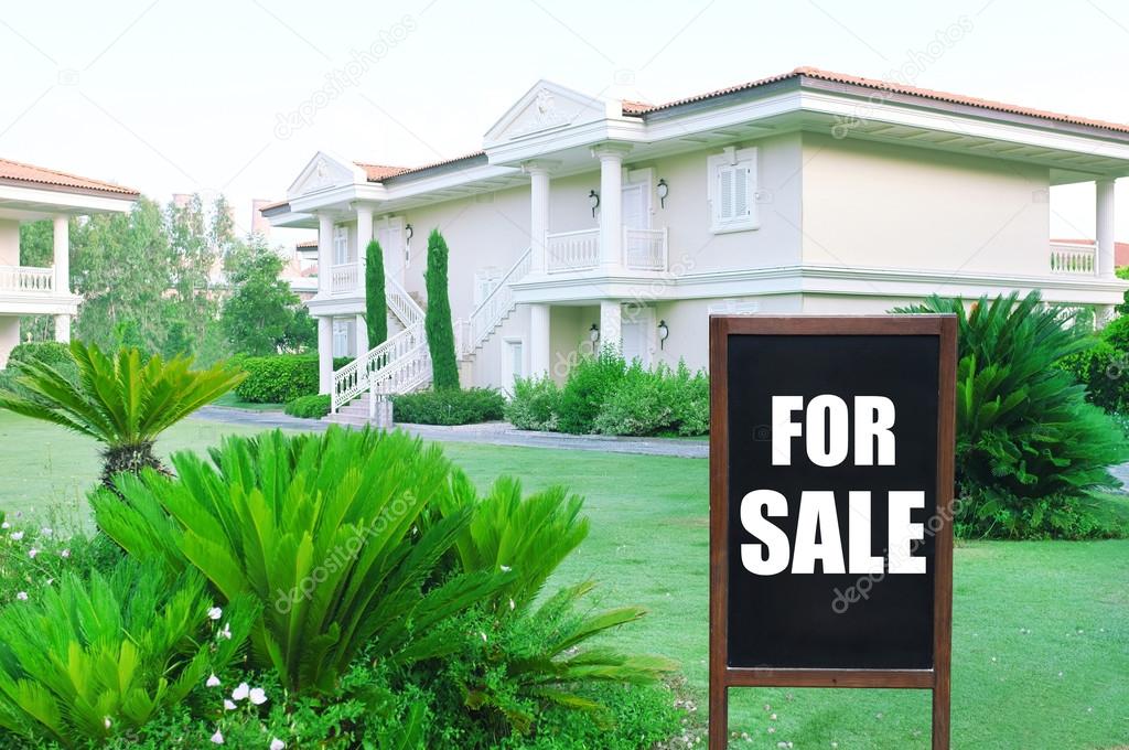 Real estate sign in front of new house for sale