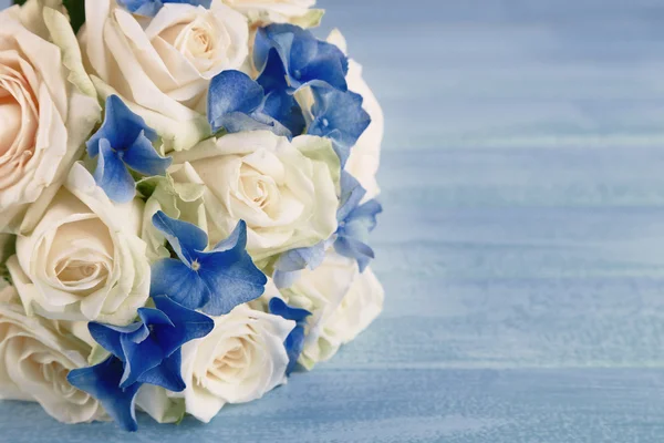 Прекрасный свадебный букет с розами на голубом деревянном столе — стоковое фото