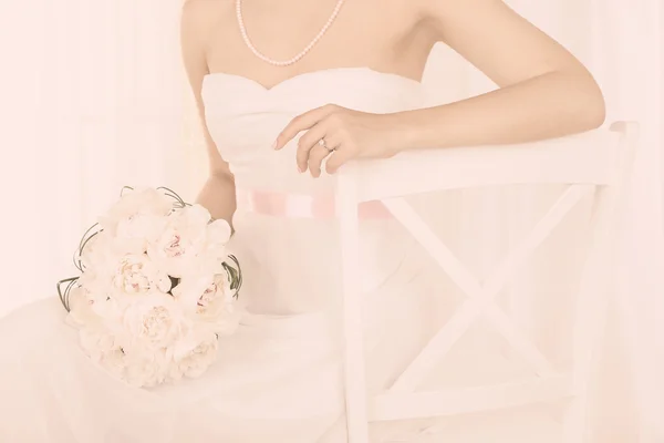 Bride holding wedding bouquet of white peonies, close-up, on light background — Stock Photo, Image