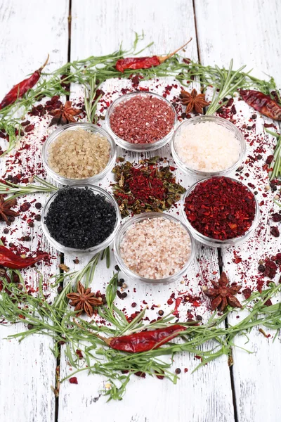 Spices in glass round bowls with herbs and chilly pepper on wooden background — Stock Photo, Image