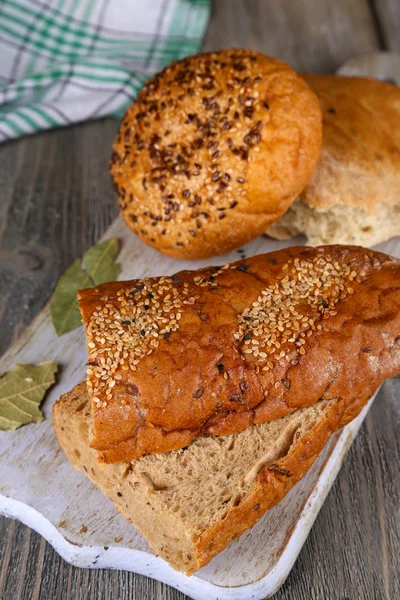 Pane appena sfornato sul tagliere, su fondo di legno — Foto Stock