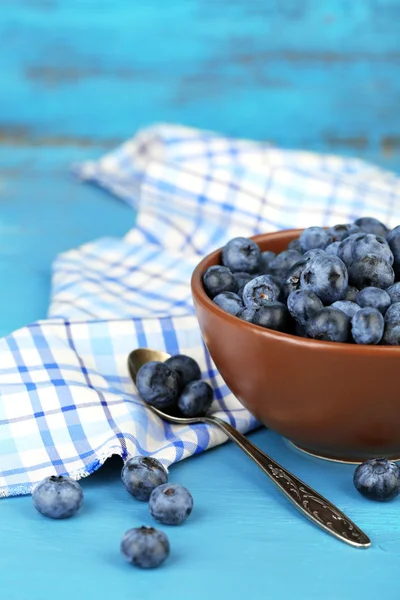 Bleuets mûrs savoureux dans un bol, sur une table en bois — Photo