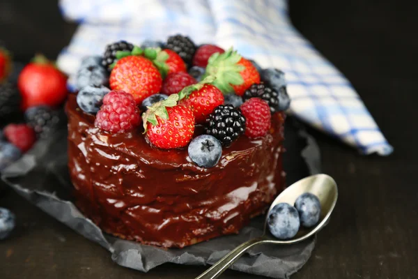 Вкусный шоколадный торт с различными ягодами на деревянном столе — стоковое фото