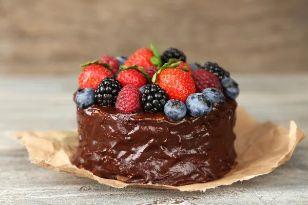 Tasty chocolate cake with different berries on wooden table — Stock Photo, Image