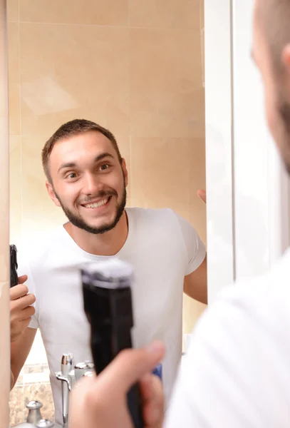 Jovem barbear sua barba no banheiro — Fotografia de Stock