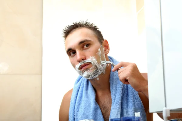 Jovem barbear sua barba no banheiro — Fotografia de Stock