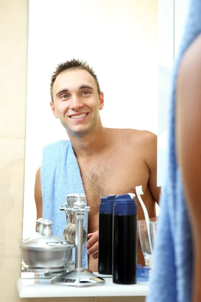 Mladý muž holení jeho vousy v koupelně — Stock fotografie
