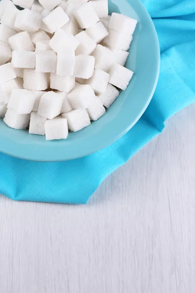 Sucre raffiné dans un bol de couleur sur fond en bois — Photo