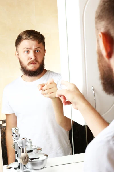 Jongeman scheren zijn baard in badkamer — Stockfoto