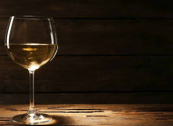 Calice di vino bianco su tavolo in legno su fondo parete in legno — Foto Stock