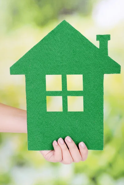 Donna mano tenendo casa di carta su sfondo luminoso — Foto Stock