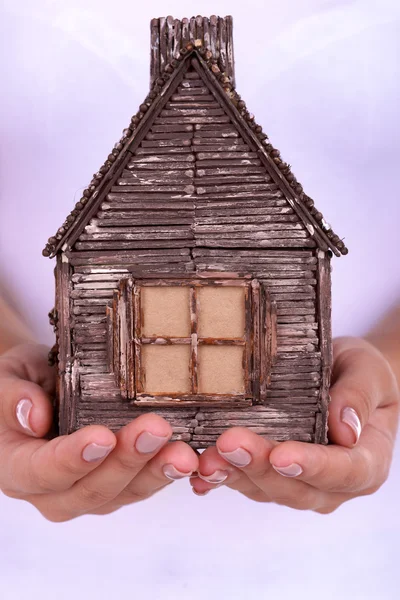 Руки женщины держат маленький дом вблизи — стоковое фото