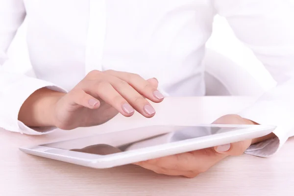 Woman using digital tablet on light background — Stock Photo, Image