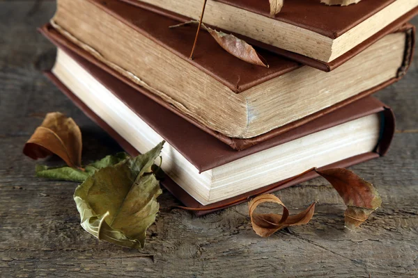 Libros y hojas secas sobre fondo de madera —  Fotos de Stock