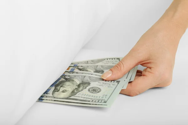 Woman hiding money under pillow at home — Stock Photo, Image