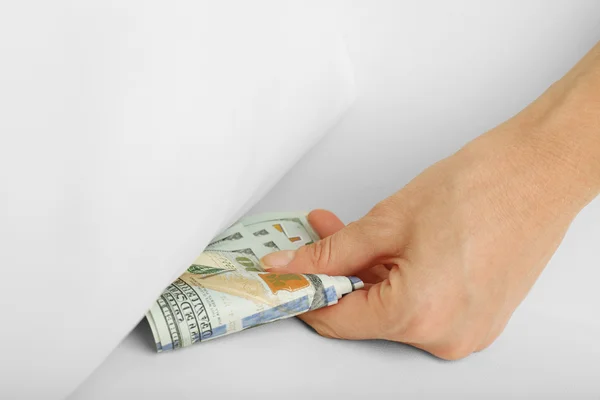 Woman hiding money under pillow at home — Stock Photo, Image