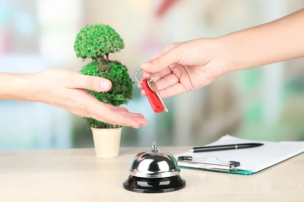 Hand giving hotel key — Stock Photo, Image