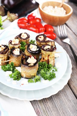 ahşap zemin üzerinde yuvarlak bir tabak içinde süzme peynir ile kızarmış patlıcan