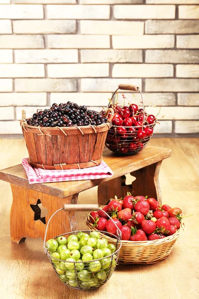 Frische Beeren im Korb auf Wandhintergrund — Stockfoto