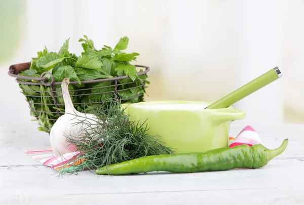 Sartén verde de crema y un mechón de eneldo y ajo sobre una servilleta sobre fondo de madera —  Fotos de Stock