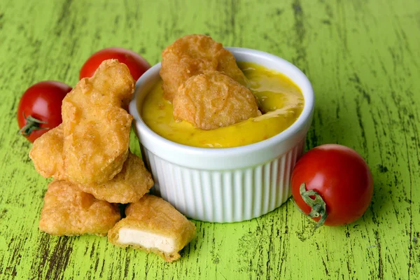 Kipnuggets met saus op tabel close-up — Stockfoto