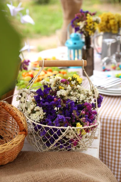 Panier avec des fleurs sur la table — Photo