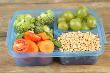 ahşap masa üzerinde plastik kutu lezzetli Vejetaryen yiyecekler