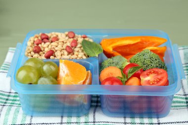 Yeşil ahşap masa üzerinde plastik kutu lezzetli Vejetaryen yiyecekler